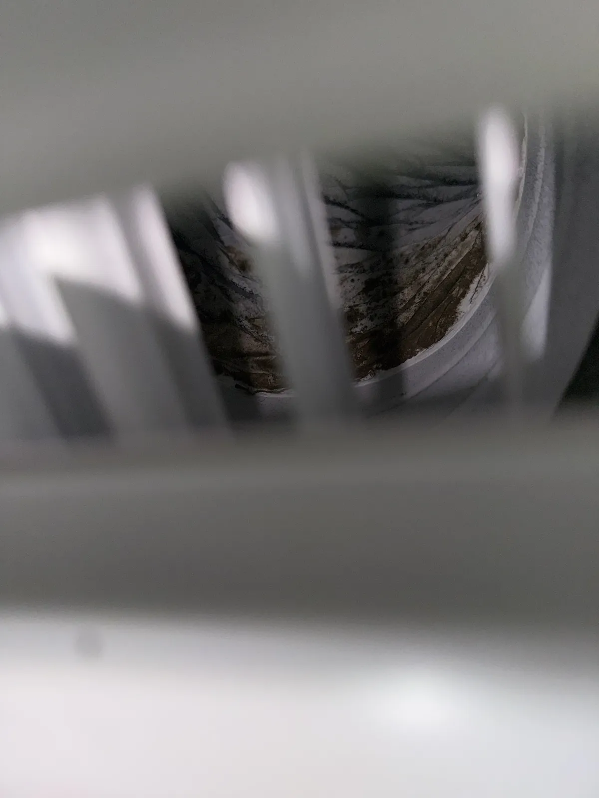 Dirty ductwork visible behind a supply vent in a Nokomis home before service